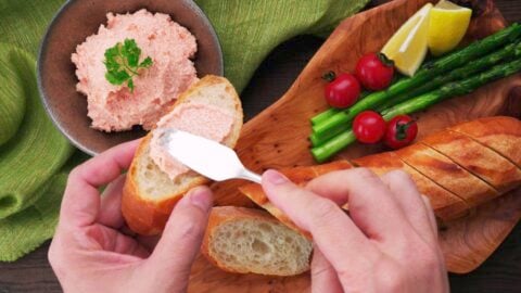 Spreading mentaiko spread onto crusty French bread.