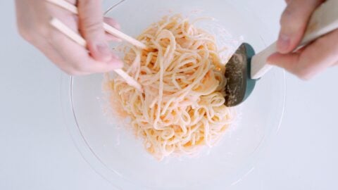 Tossing spaghetti with creamy Mentaiko pasta sauce.