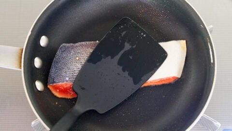 Miso Salmon being pan fried. Pressing on the salmon with a spatula ensures even browning.