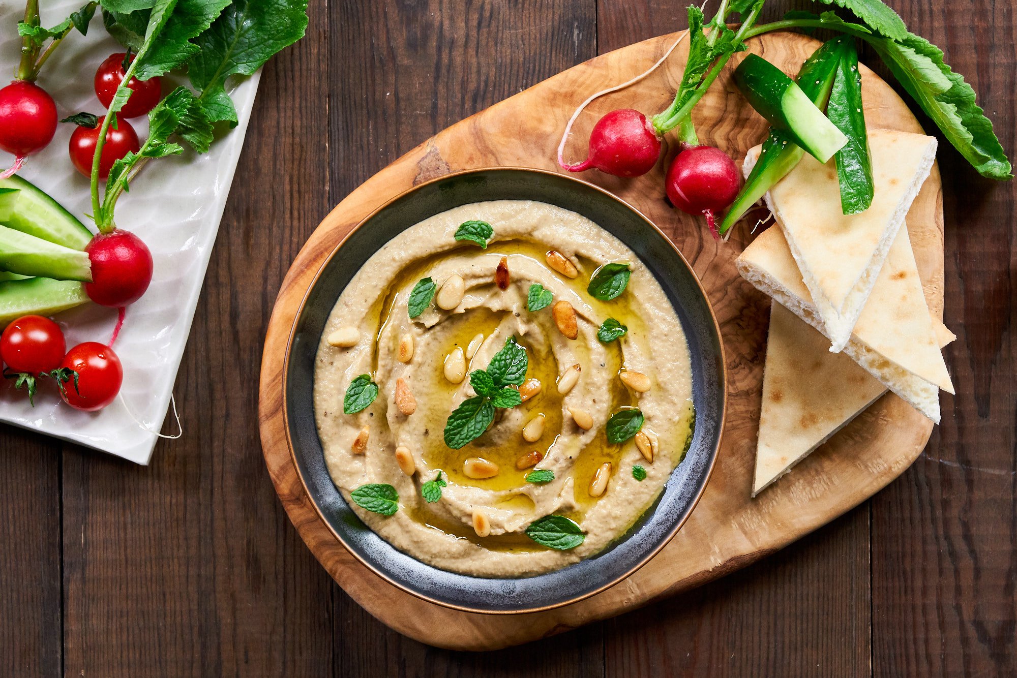 The best Mutabbal garnished with mint and toasted pine nuts. Served with pita, radishes, cucumbers and cherry tomatoes.