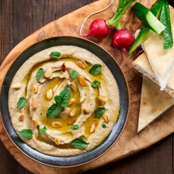 The best Mutabbal garnished with mint and toasted pine nuts. Served with pita, radishes, cucumbers and cherry tomatoes.