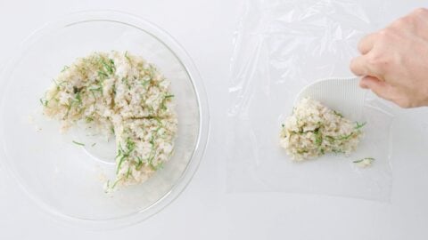 Add a quarter of the rice to a sheet of plastic wrap to shape the onigiri.