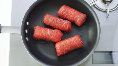 Pan-frying meat wrapped onigiri.