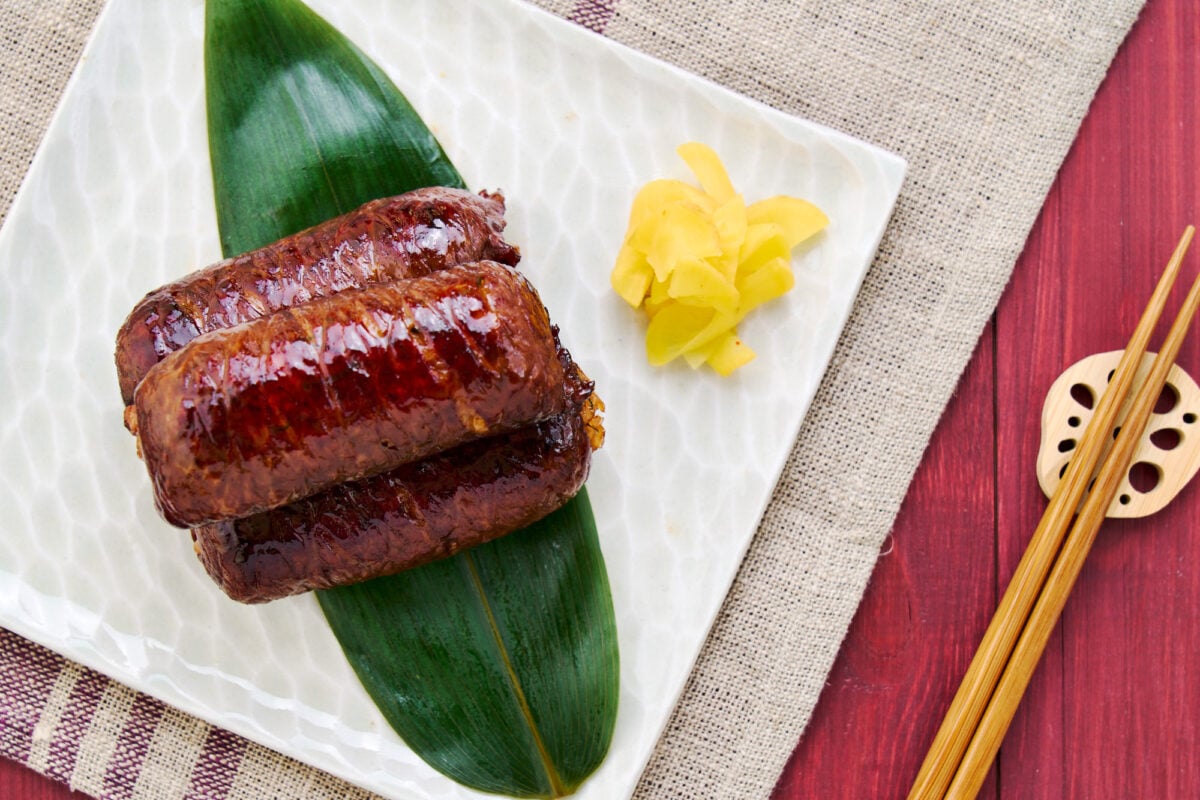 Nikumaki Onigiri or "meat wrapped onigiri" is a flavorful bundle of rice that's wrapped in a thin sheet beef before being glazed in sweet and savory teriyaki sauce.