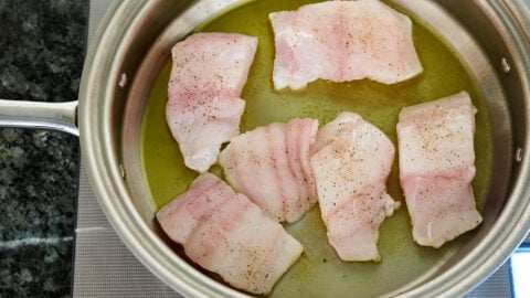 Sear the cod in a very hot pan with olive oil to form a brown crust and keep the delicate fish from sticking to the pan.