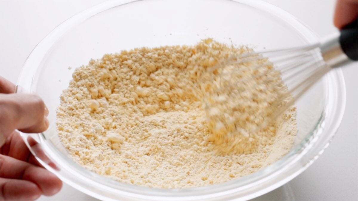 Dry ingredients in a glass bowl being whisked together.