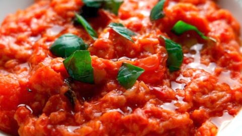 Pappa al Pomodoro garnished with a drizzle of olive oil and torn basil leaves.