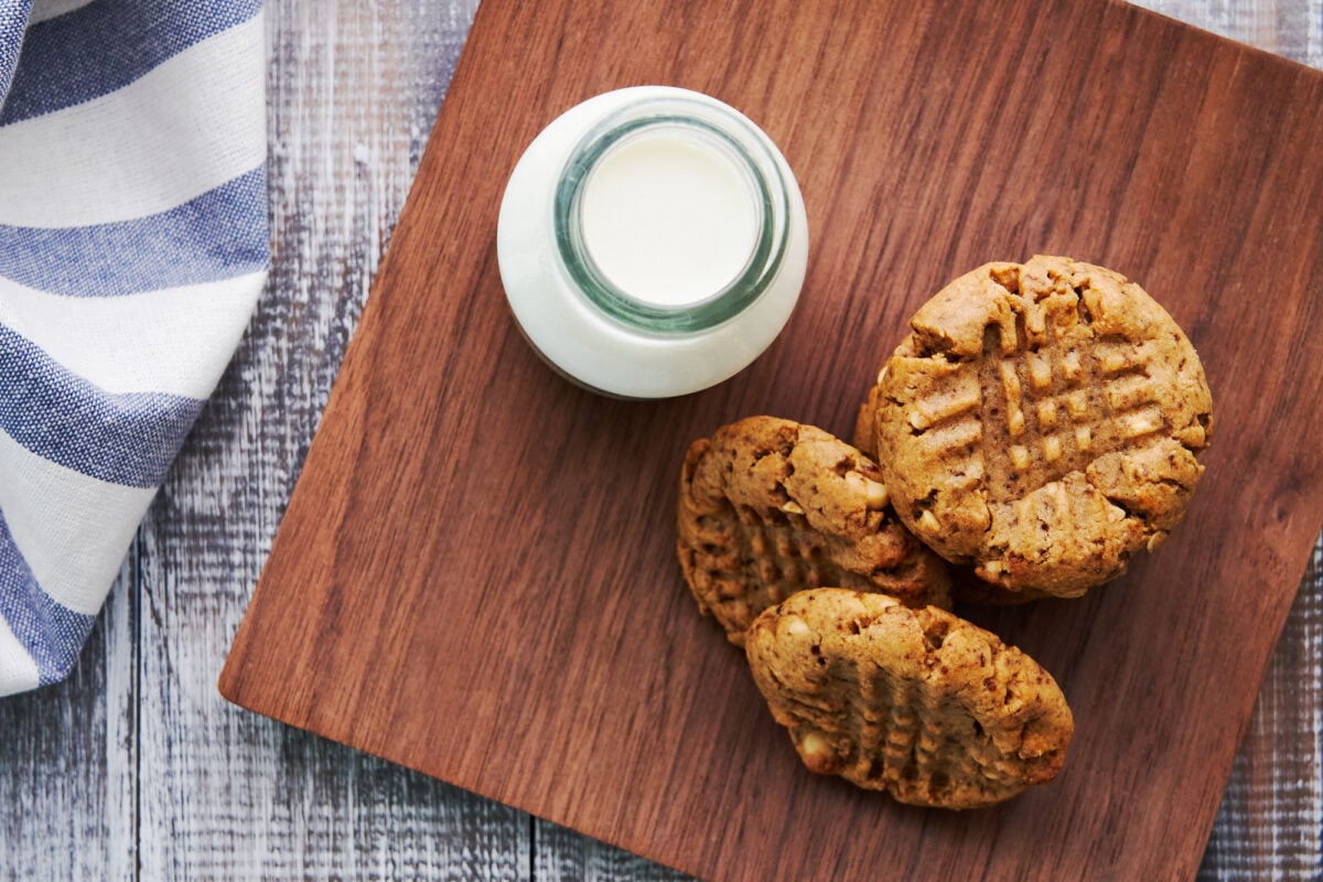 Healthy plant-based Peanut Butter Cookies on a wooden plate with almond milk.