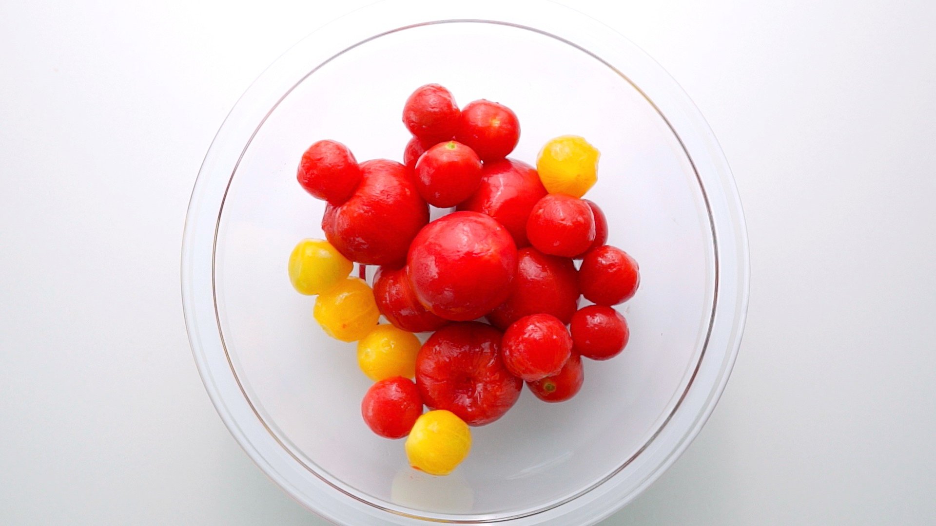 Overhead shot of a bowl of peeled tomatoes.