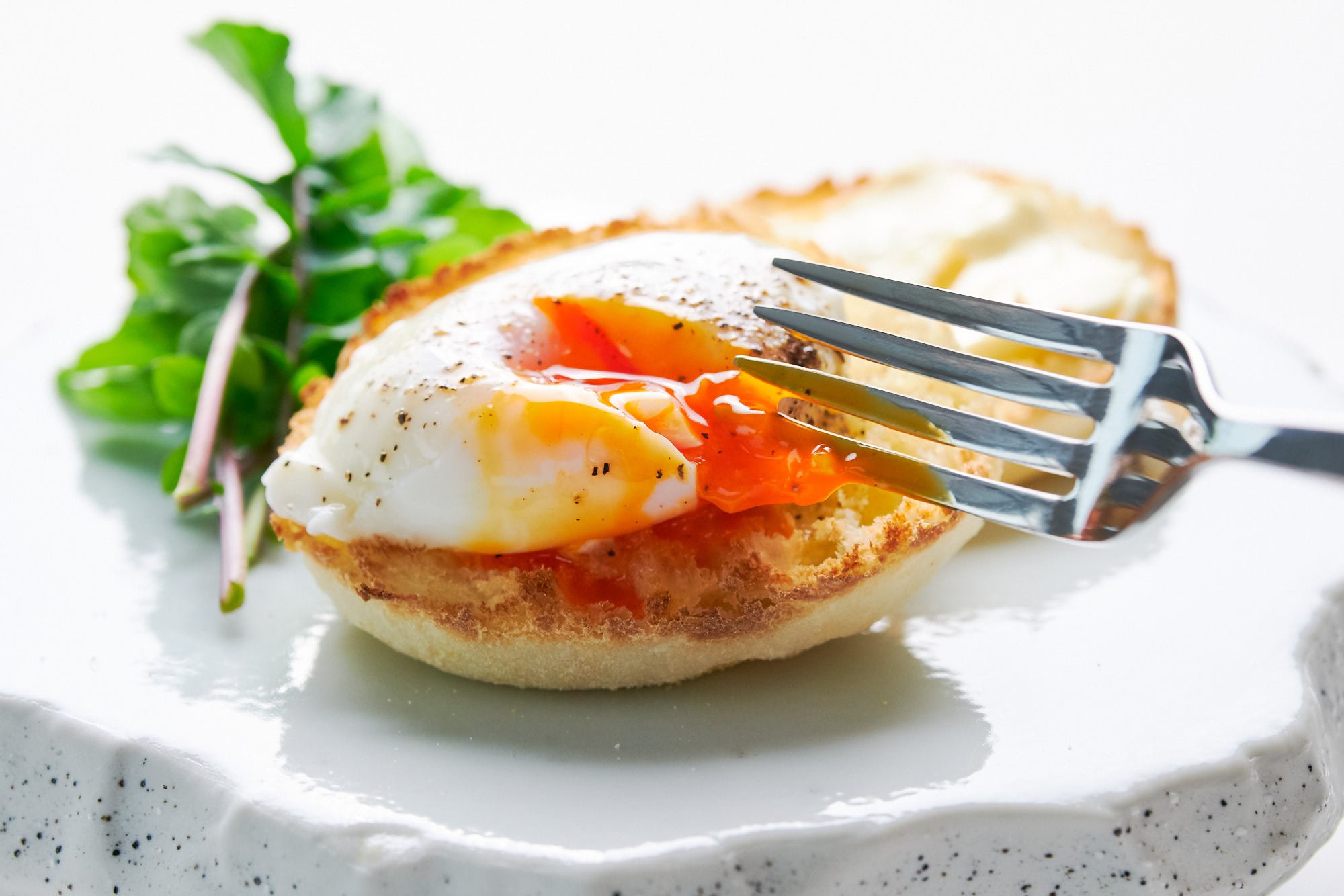 Breaking the yolk of a perfectly poached egg with a fork.