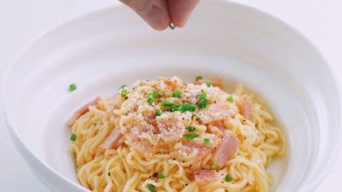 Sprinkle the finished ramen carbonara with scallions.