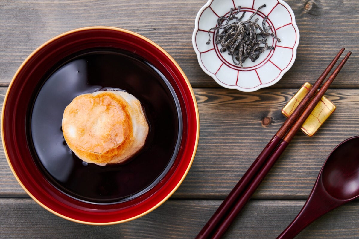 Toasted mochi (rice cake) floating in a bowl of sweet red bean soup.