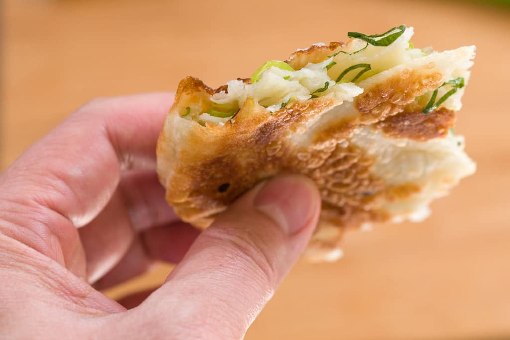 By avoiding the temptation to roll out your scallion pancakes too thin you get nice layers of dough making the finished pancake flaky.