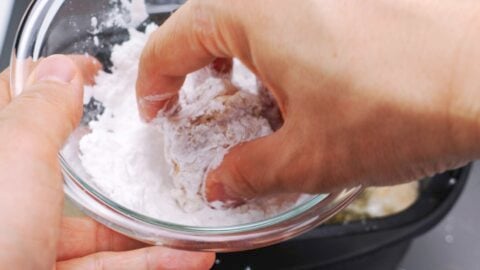 Dusting karaage chicken with potato starch.