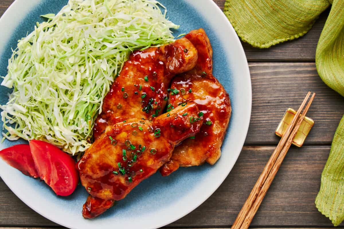 Japanese pork chops marinagted in ginger and glazed with a savory sauce. Served with shredded cabbage and tomatoes.