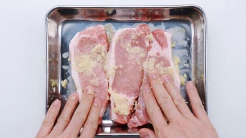 Marinating pork chops in ginger to make shogayaki.