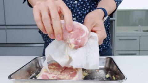 Removing excess ginger from shogayaki pork chops.