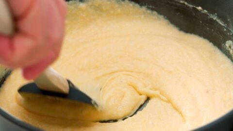 Stirring grits in a large pot.