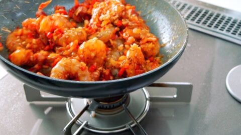 Tossing Cajun shrimp in a frying pan.