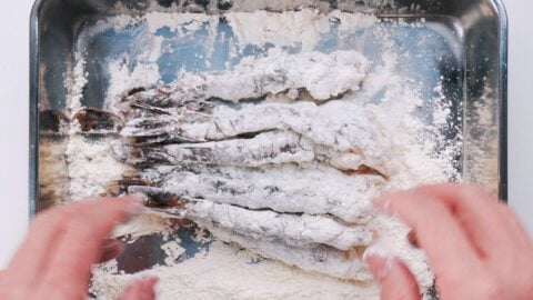 Dusting shrimp with flour for making tempura.