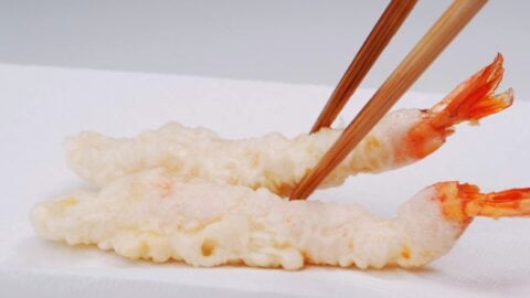 Shrimp tempura draining on paper towels.