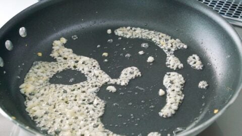 Stir-frying garlic and ginger in a frying pan.