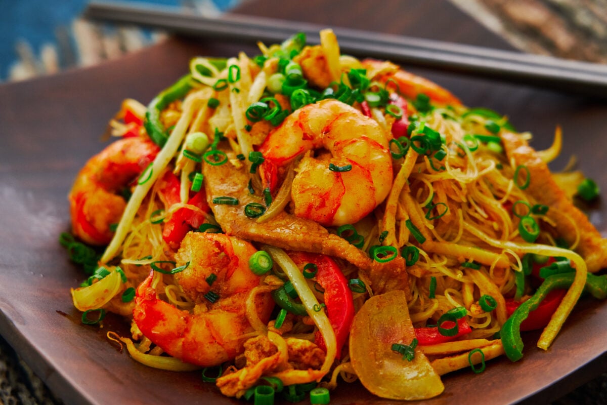 A mouthwatering plate of curry-flavored Singapore Noodles loaded with shrimp, pork, bean sprouts, and bell peppers.