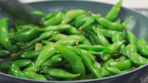 Garlic and edamame in a frying pan.