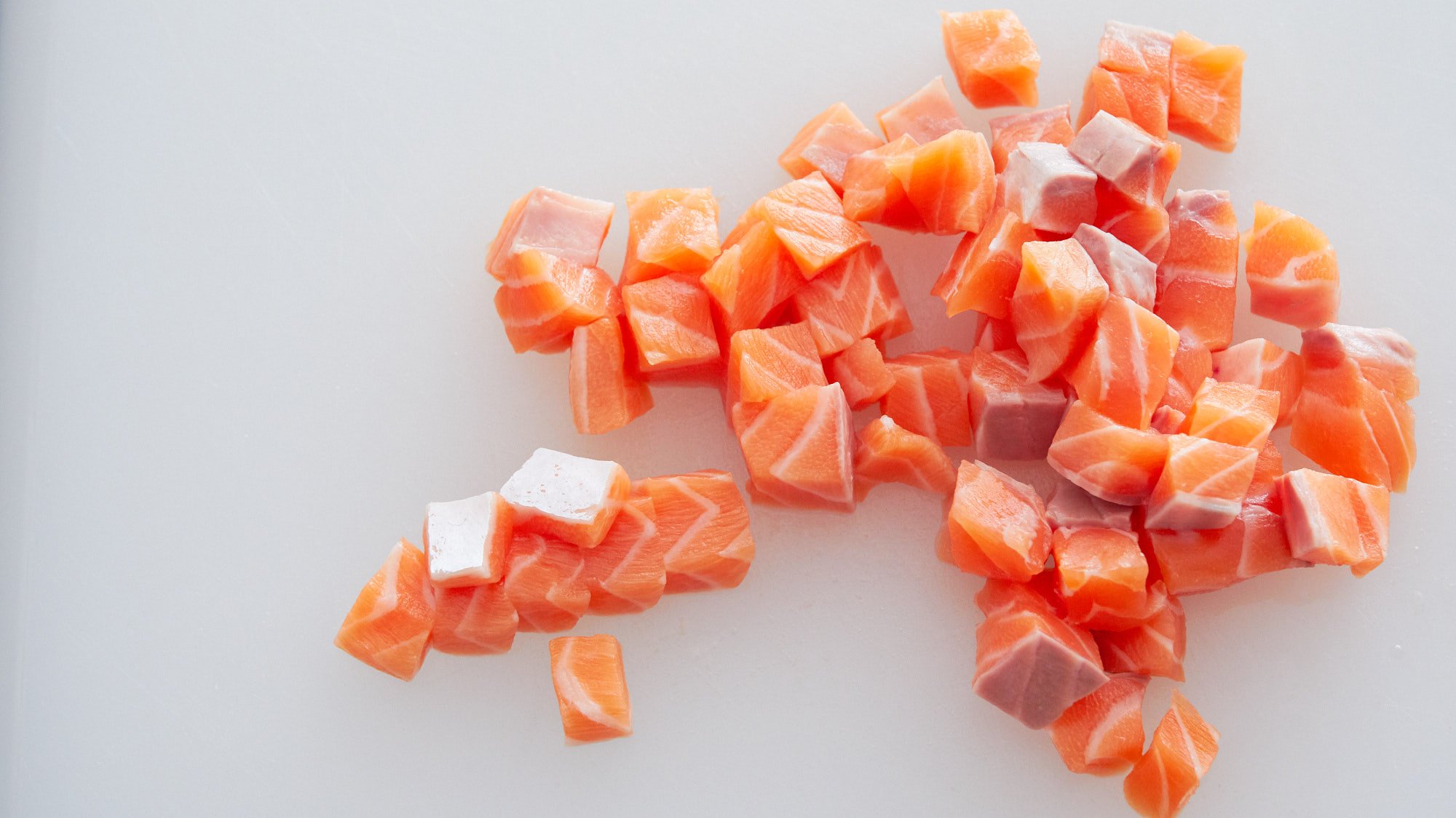 Raw salmon cut into cubes for making Spicy Salmon Poke.