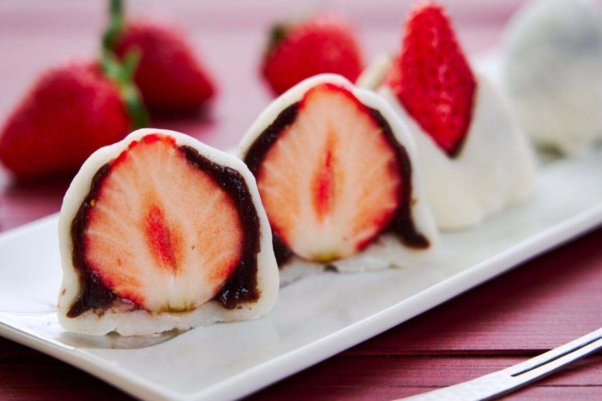 Cross-section of Strawberry Mochi showing a juicy strawberry wrapped in sweet red bean paste and sticky mochi.