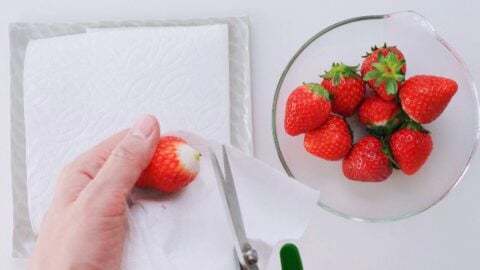 Trim the leaves and stem off of each strawberry.