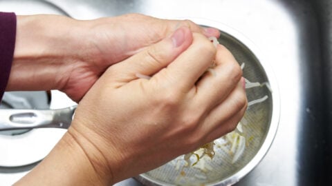 To ensure your Sukju Namul does not get watery, it's important to squeeze the blanched bean sprouts well.