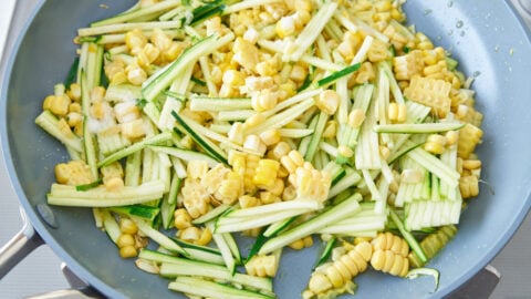 Corn, zucchini and garlic sauteing in a pan for making the best summer pasta.