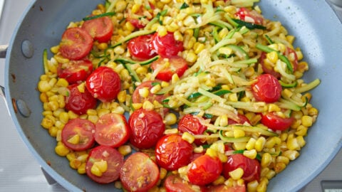 Pan-roasted cherry tomatoes with corn and zucchini for Summer Pasta.