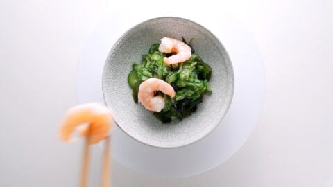 Placing shrimp on top of Sunomono (Japanese Cucumber Salad)