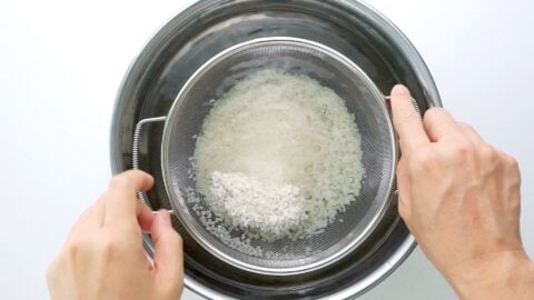 Washing sushi rice in cold water.