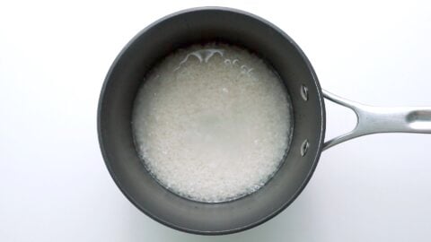 Soaking the rice in water before cooking.