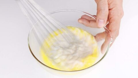 Whisking butter and milk together in a bowl for making Taiyaki Batter.