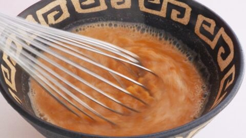 Whisking spicy ramen broth with sesame taré.