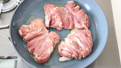 Chicken teriyaki starts off with chicken thighs skin-side down in a non-stick frying pan over medium heat.