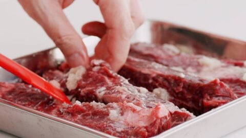 Marinating hanger steaks with ginger and garlic for beef teriyaki.