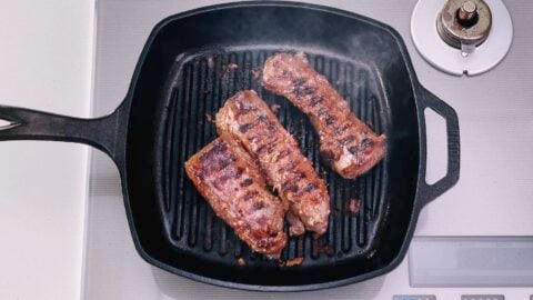 Overhead shot of hanger steaks on grill pan with grill marks.