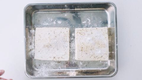 Drained tofu seasoned with black pepper and dusted with potato starch.