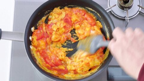 Scrambling eggs with stir-fried tomatoes.