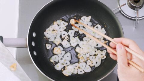 Frying garlic chips until crispy.