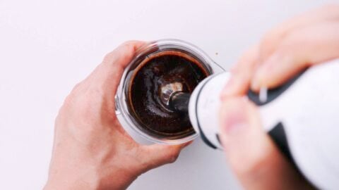 Blending triple garlic sauce with a hand blender.