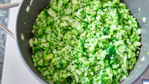 Bright green chopped broccoli in a pan for making creamy broccoli cheese soup.