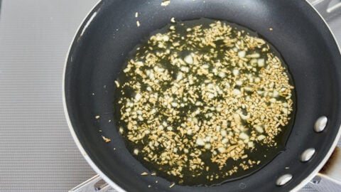 Caramelized garlic and olive oil in a frying pan to make garlic seed oil for broccoli cheese soup.