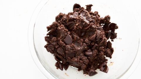 Glass bowl with vegan chocolate cookie dough with big chunks of chocolate.