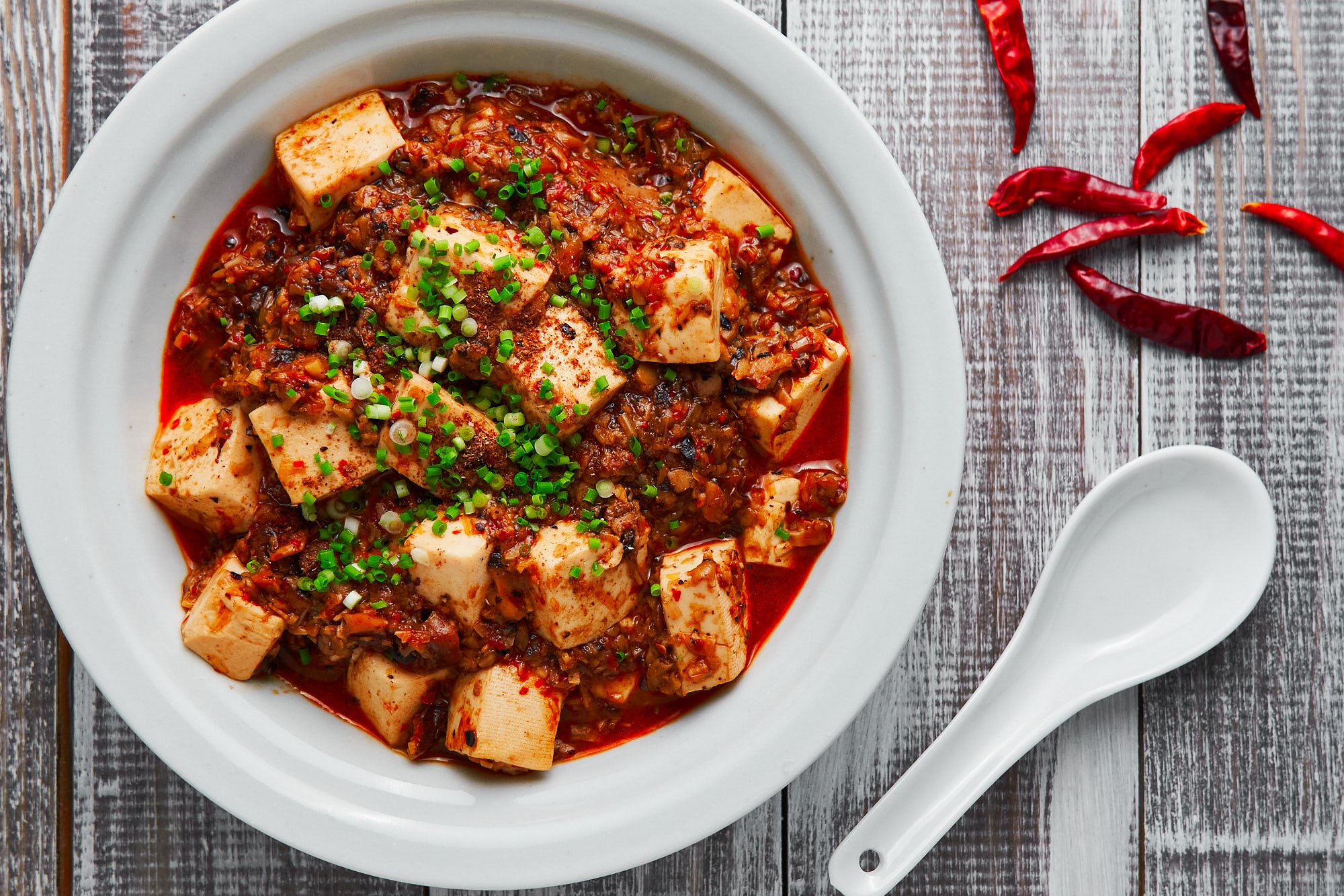 This Vegan Mapo Tofu is loaded with creamy blocks of tofu in a fiery Sichuan sauce made from ground mushrooms and fermented black soybeans.